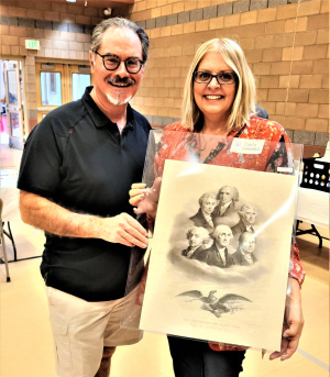 two people holding a piece of art
